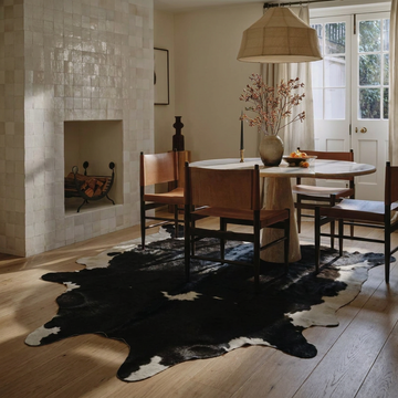 Natural cowhide rug styled on the floor of an editorial interior room