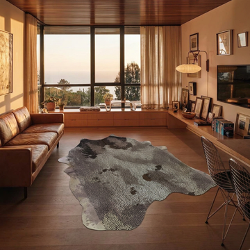 Distressed brown and grey acid-wash cowhide rug styled on the oak floor of a mid-century timber living room
