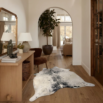 Natural cowhide rug styled on the floor of an editorial interior room
