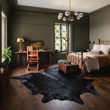 Warm caramel solid natural cowhide rug styled on the floor of an editorial interior