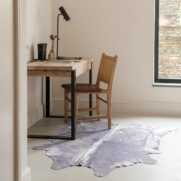 Lilac metallic cowhide rug styled on the pale floor of a minimal Scandinavian home office