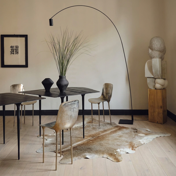 Caramel and ivory exotic printed cowhide rug styled on the floor of an editorial interior
