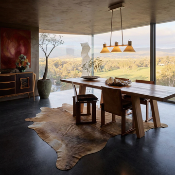 Caramel and ivory exotic printed cowhide rug styled on the floor of an editorial interior