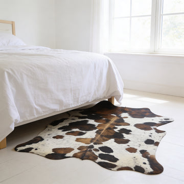 HN-23216 cowhide rug at foot of bed in bedroom