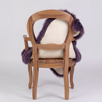 Purple sheepskin over an armchair back, suede leather underside facing the camera