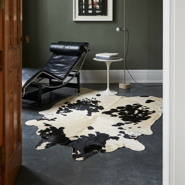 Caramel and ivory exotic printed cowhide rug styled on the floor of an editorial interior