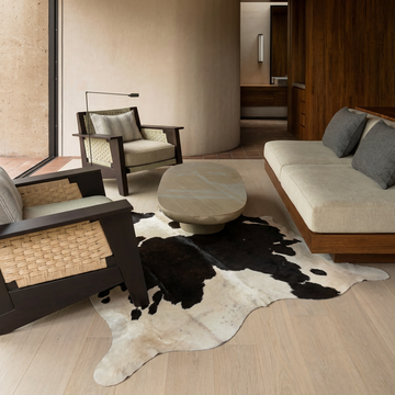 Caramel and ivory exotic printed cowhide rug styled on the floor of an editorial interior