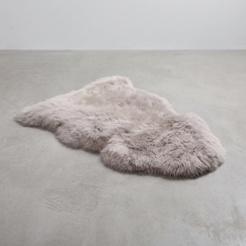 Light Grey single sheepskin rug laid flat on a pale grey floor
