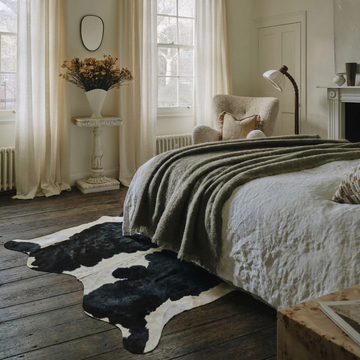 Caramel and ivory exotic printed cowhide rug styled on the floor of an editorial interior