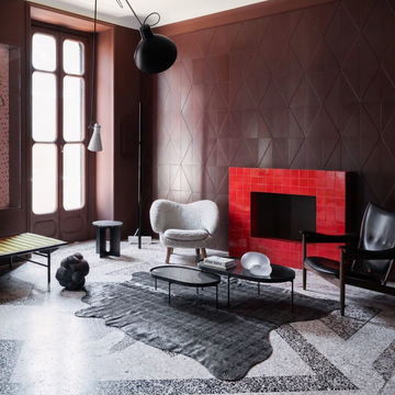 Charcoal snakeskin-embossed cowhide rug styled on the terrazzo floor of a moody luxe oxblood living room