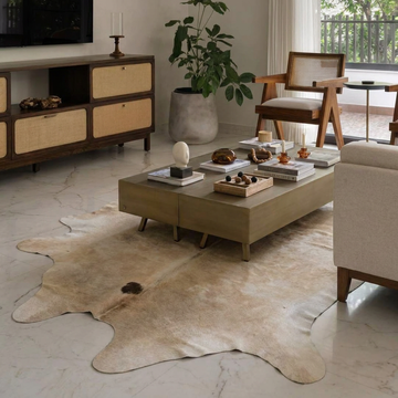 Natural cowhide rug styled on the floor of an editorial interior room