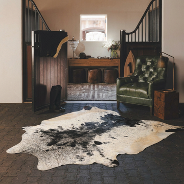 Caramel and ivory exotic printed cowhide rug styled on the floor of an editorial interior