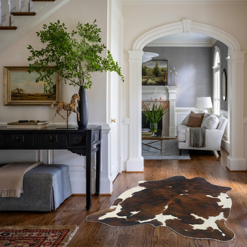 Tri colour brindle cowhide rug styled on the oak floor of a classic entry hall