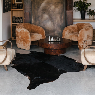 Natural cowhide rug styled on the floor of an editorial interior room