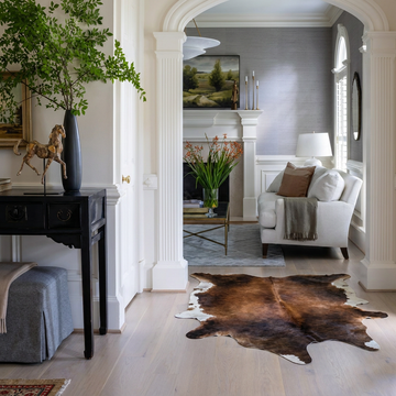 Caramel and ivory exotic printed cowhide rug styled on the floor of an editorial interior