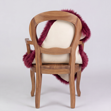 Raspberry sheepskin over an armchair back, suede leather underside facing the camera