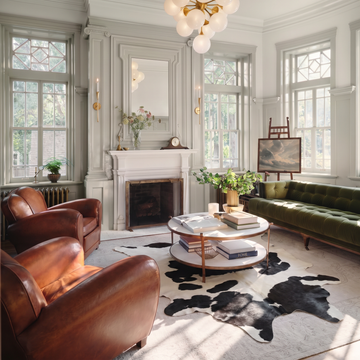 Black and white cowhide rug styled on the floor of an elegant chesterfield living room