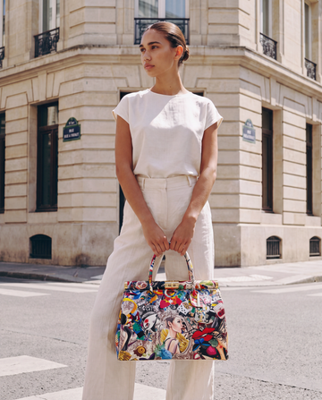 Woman with the Dalia leather top-handle bag by Clemés, pop-art print, standing at a city street corner
