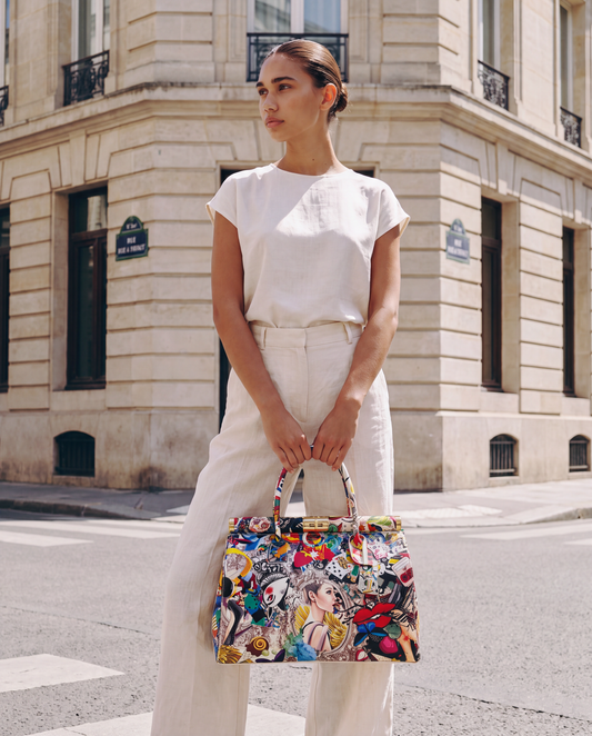 Woman with the Dalia leather top-handle bag by Clemés, pop-art print, standing at a city street corner