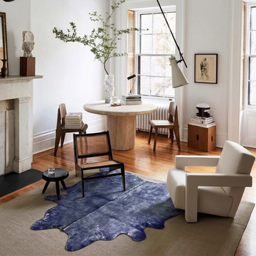Indigo metallic cowhide rug layered on a sisal rug in a bright white period living room