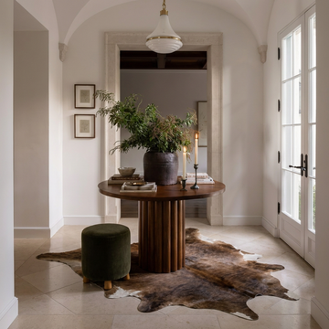 Caramel and ivory exotic printed cowhide rug styled on the floor of an editorial interior