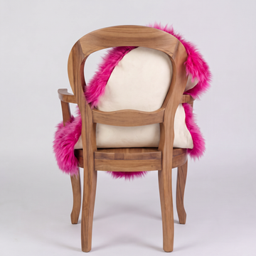 Fuchsia sheepskin over an armchair back, suede leather underside facing the camera