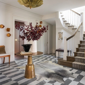 Grey cowhide rug styled on the marble tile floor of an elegant cool-toned entryway