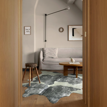 Silver brushed grey and white metallic cowhide rug styled on the oak floor of a minimal attic sitting room