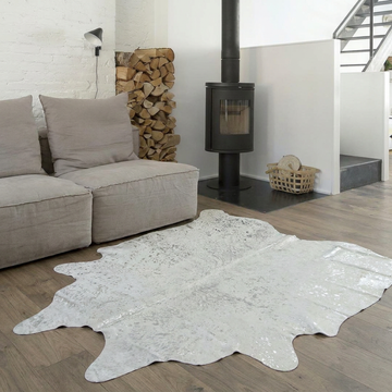 Silver metallic cowhide rug styled on the oak floor of a Scandinavian living room