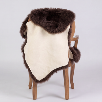 Chocolate sheepskin over an armchair back, suede leather underside facing the camera