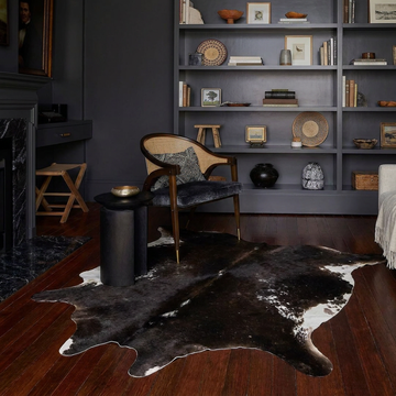 Natural cowhide rug styled on the floor of an editorial interior room