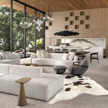 Caramel and ivory exotic printed cowhide rug styled on the floor of an editorial interior