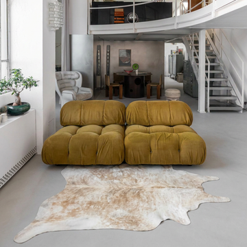 Natural cowhide rug styled on the floor of an editorial interior room