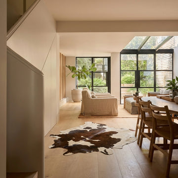 Caramel and ivory exotic printed cowhide rug styled on the floor of an editorial interior