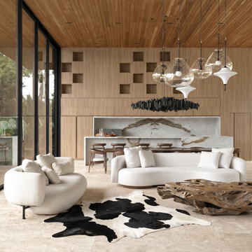 Espresso and ivory Holstein cowhide rug styled on the floor of a bright modern loft living room