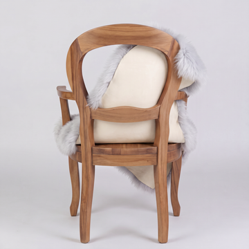 Silver sheepskin over an armchair back, suede leather underside facing the camera