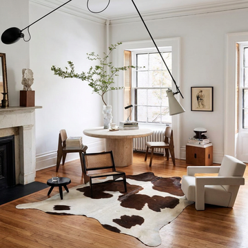 Caramel and ivory exotic printed cowhide rug styled on the floor of an editorial interior