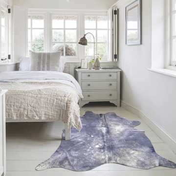 Lilac metallic cowhide rug styled beside the bed in a bright white cottage bedroom