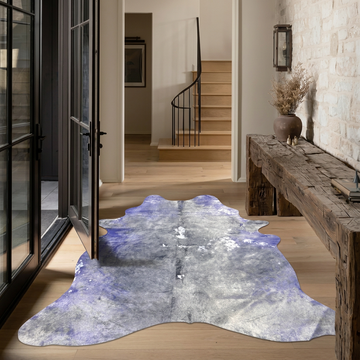 Violet and Grey metallic cowhide rug styled on the oak floor of a warm rustic entry hall