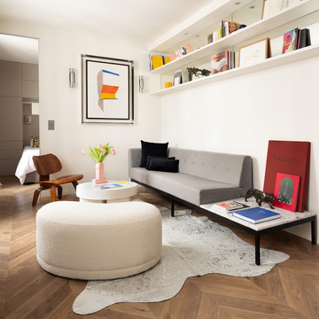 Silver metallic cowhide rug styled on the chevron parquet of a modern Parisian living room
