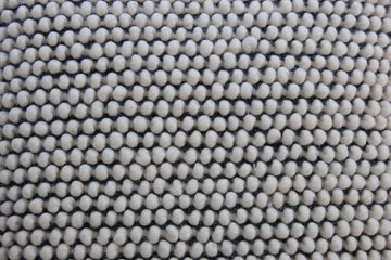 Detail of the Salt & Pepper cushion's raised ivory wool bobble texture over a black weave