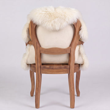 Ivory sheepskin over an armchair back, suede leather underside facing the camera