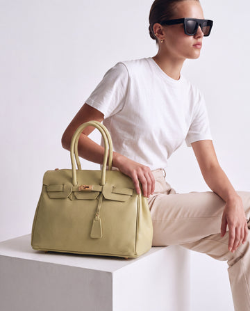 Model seated with the Lemon Valentina Maxi Leather Tote, studio editorial shot
