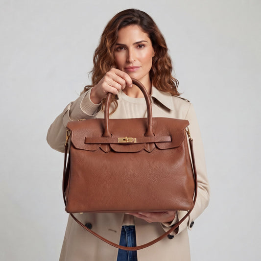 Model holding up the Cognac Valentina Maxi Leather Tote, studio detail shot