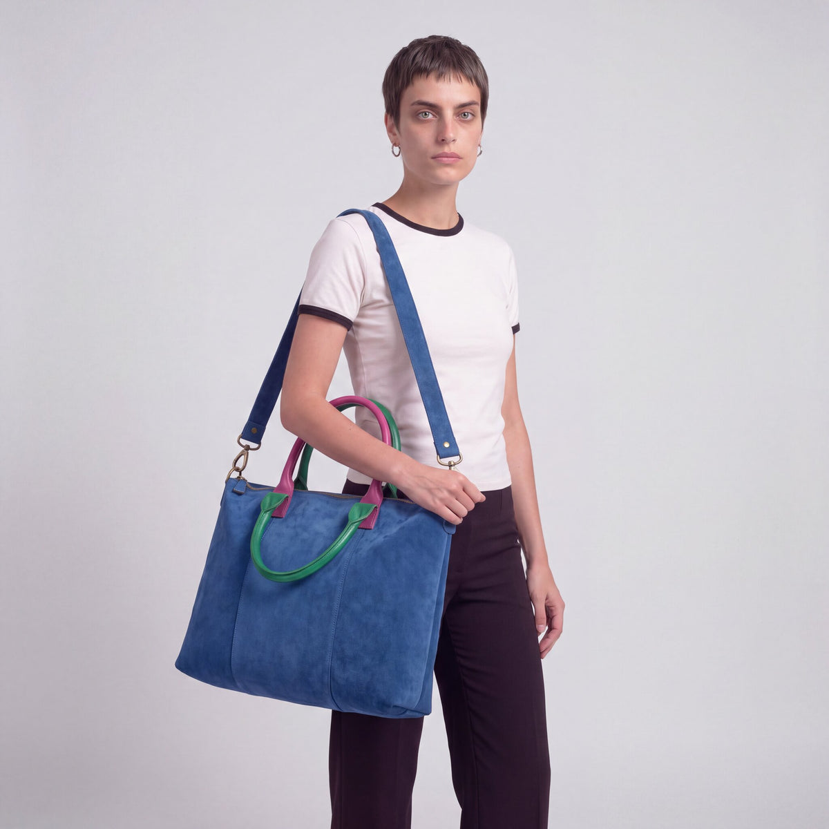 Model carrying the Blue Milano Max Suede Bag on her shoulder, studio shot