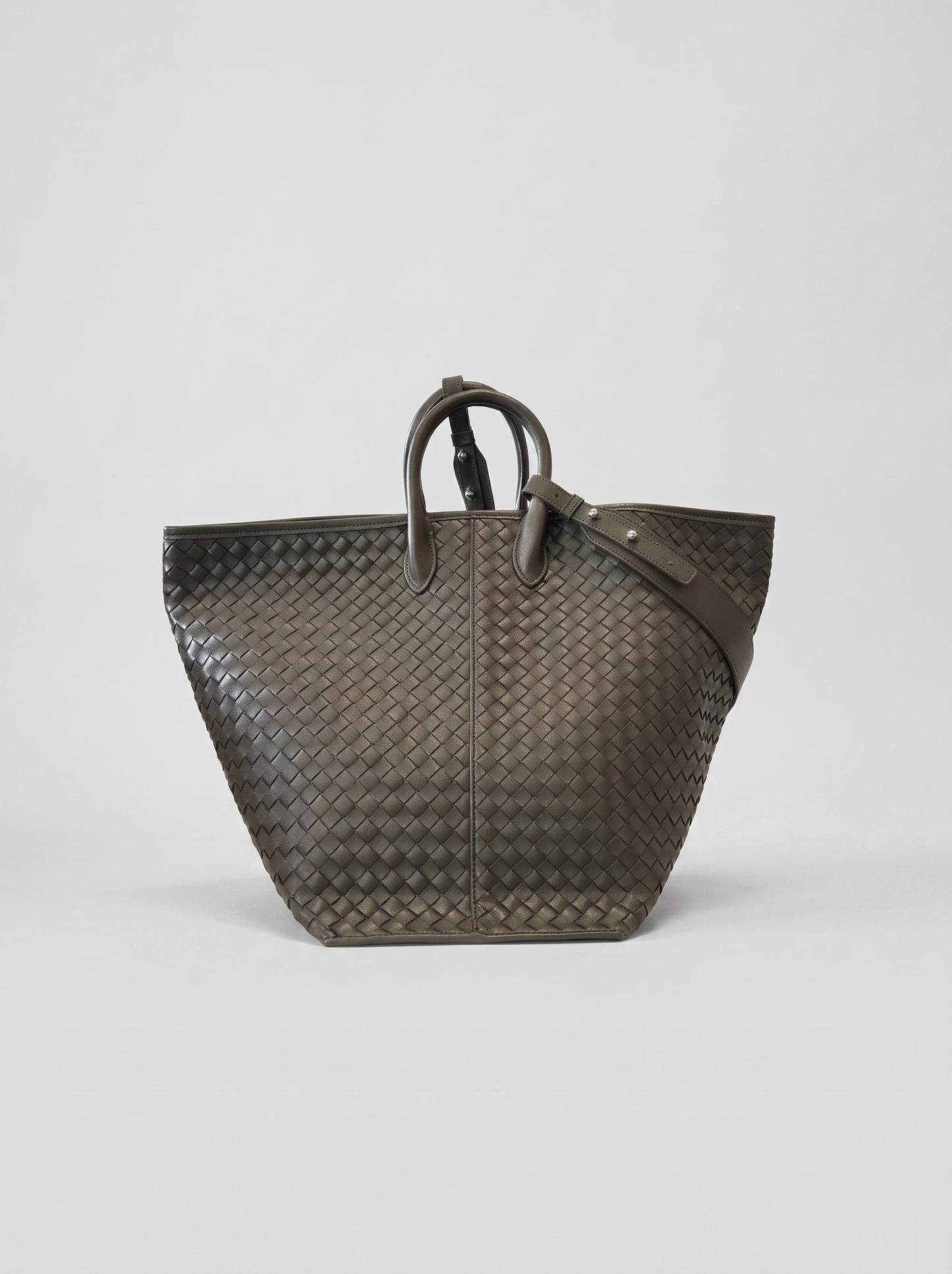 Cloe hand-woven leather bag carried as an open tote, three-quarter view