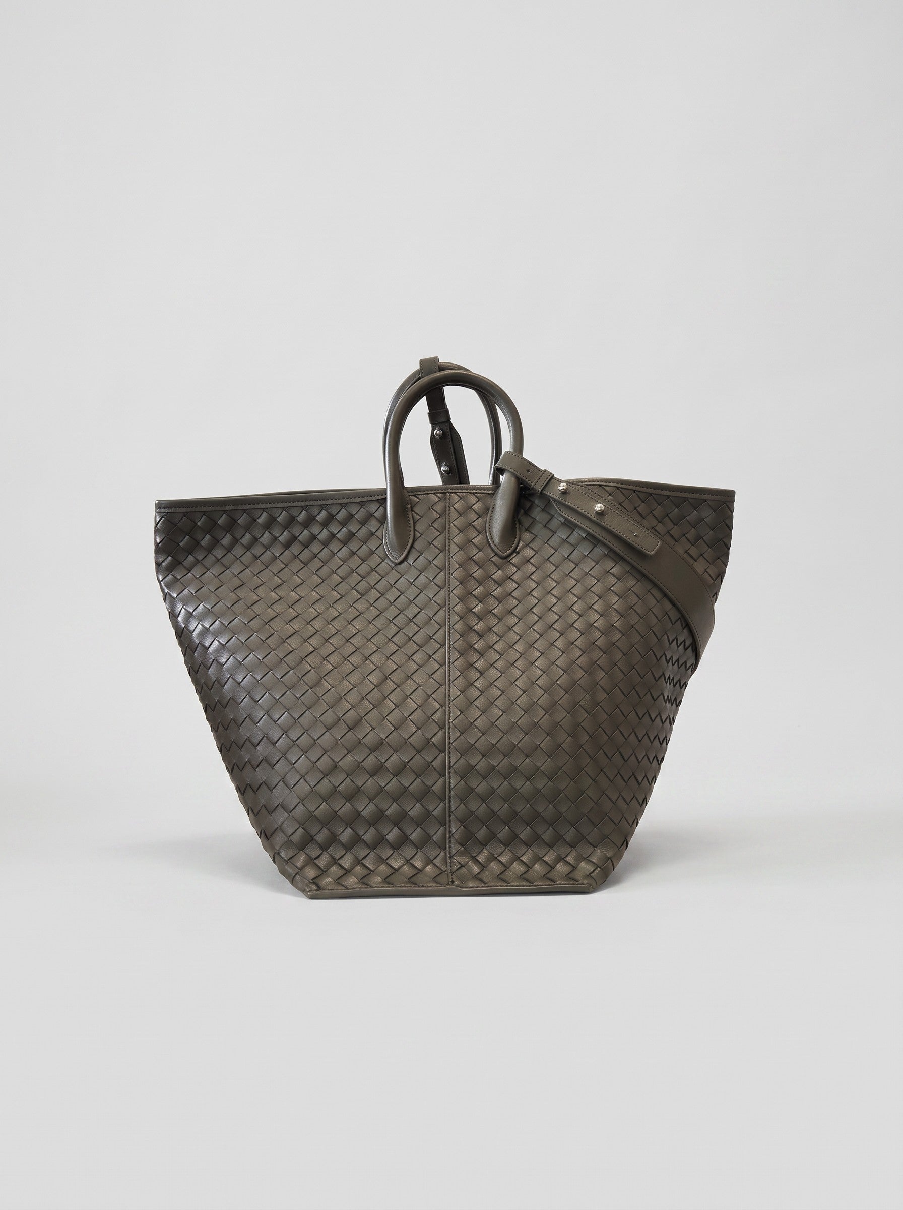 Cloe hand-woven leather bag carried as an open tote, three-quarter view