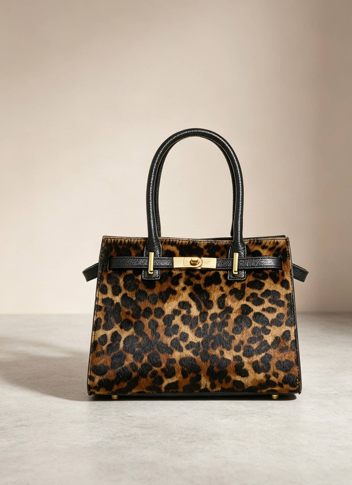 Leonora leopard calf hair bag by Clemés styled on a warm neutral backdrop