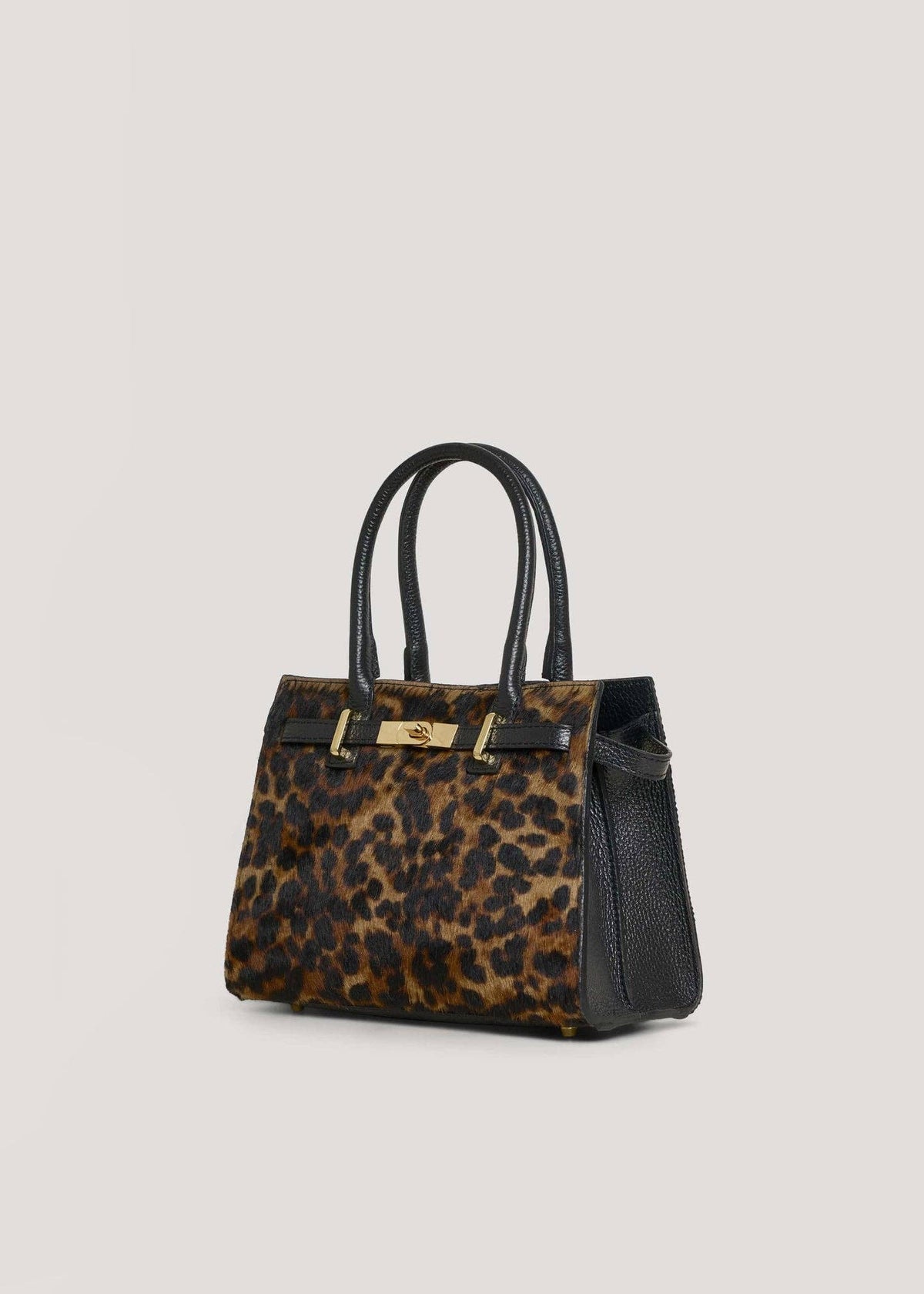 Leonora leopard calf hair bag at a three-quarter angle, showing the black Togo leather side panel and 15 cm depth