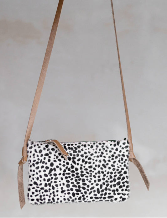 Anouk Cowhide Crossbody by Clemés in Dalmatian, three-quarter studio shot on grey background